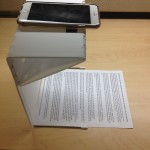 The Fopydo stand with an idevice on the top and a piece of paper below