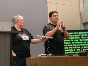 Two presenters hold XBOX adaptive controllers .